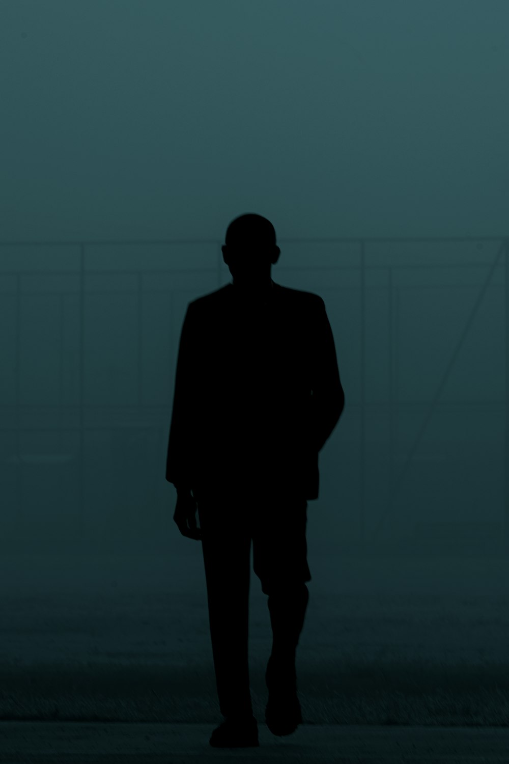 a man in a suit walking in the dark