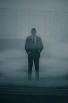 A mysterious figure standing in a foggy alleyway.