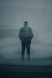 A mysterious figure standing in a foggy alleyway.