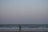 A serene beach scene with a woman walking along the shore, reflecting on her journey.