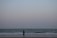 A serene beach scene with a woman walking along the shore, reflecting on her journey.
