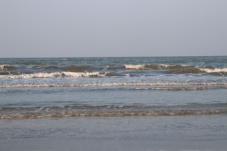 Gentle waves rolling onto a quiet sandy beach under a clear sky