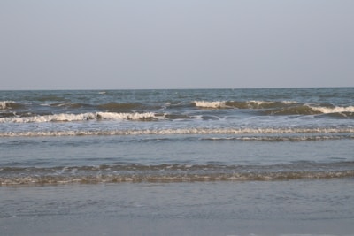 Gentle waves rolling onto a quiet sandy beach under a clear sky