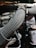 A close-up view of an engine compartment featuring braided hoses, fastened with metal clamps. The setting is dimly lit, highlighting the textures and patterns of the hoses and surrounding machinery components.