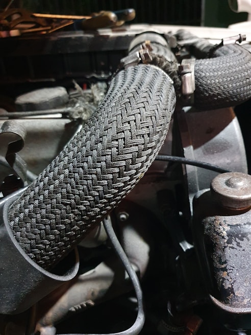 Close-up of high-pressure hydraulic hoses in a workshop setting.