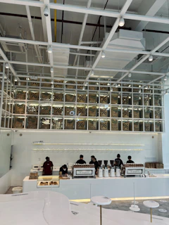 A sleek modern coffee shop interior with minimalist black and gold accents representing the specialty coffee division
