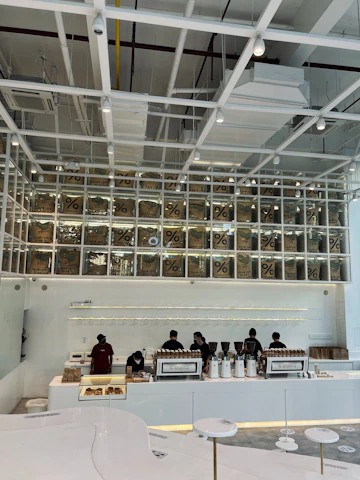 A minimalist coffee shop interior with clean white walls and navy blue accents, highlighting a welcoming partnership atmosphere.