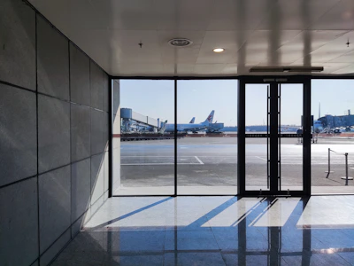 View of the Alicante Airport terminal visible just beyond the parking area.