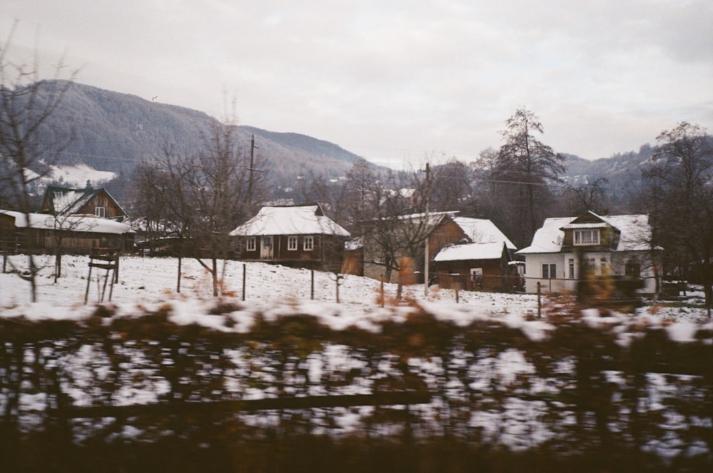 a view of a snow covered village from a moving train