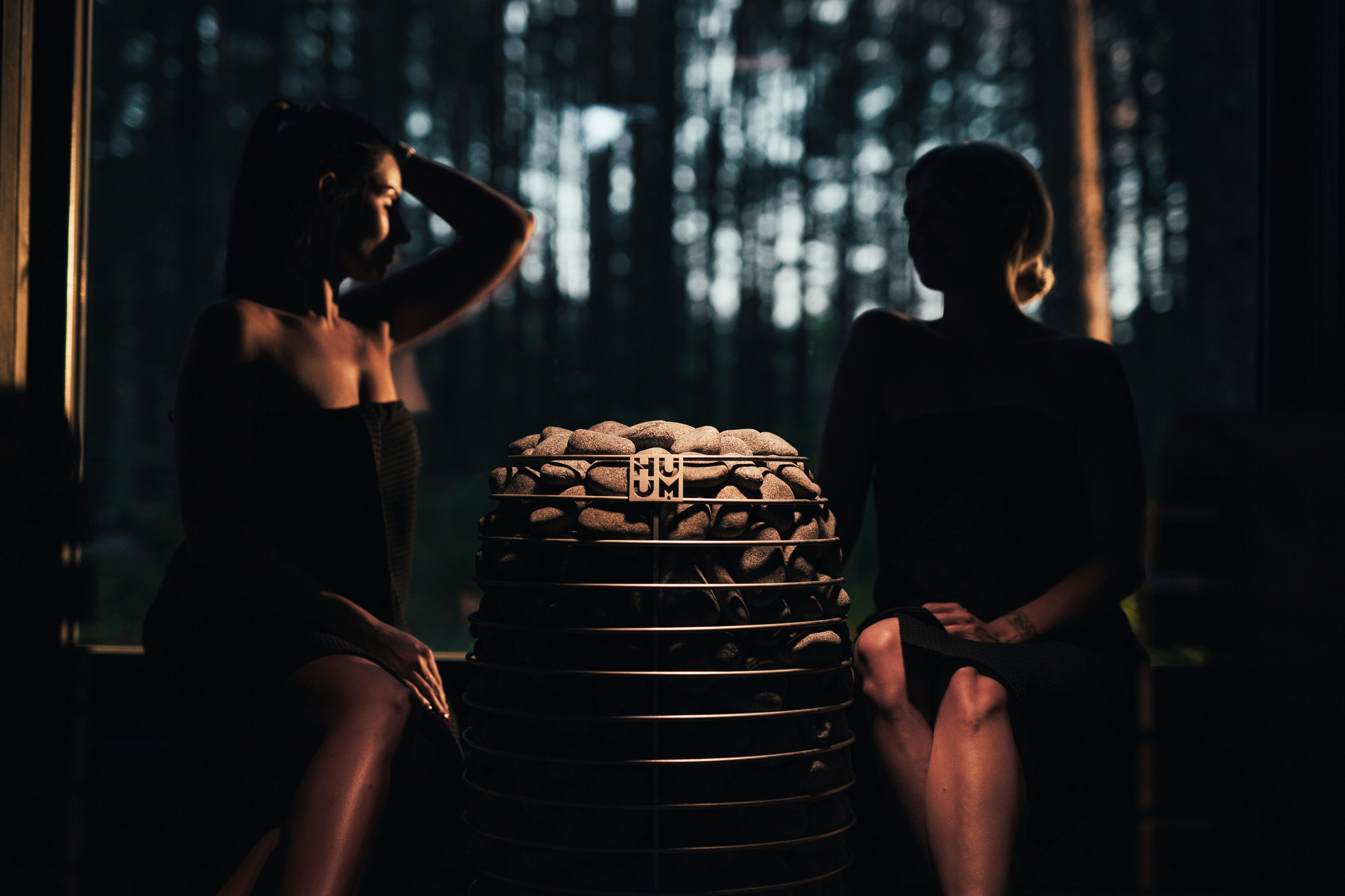 two women sitting next to a stack of stacked plates
