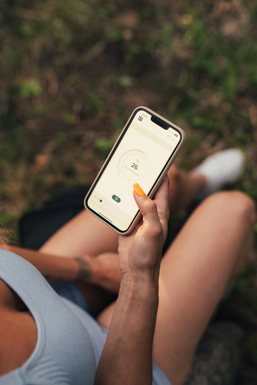 a woman sitting on the ground holding a cell phone