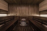 A modern sauna room with wooden benches and warm lighting.