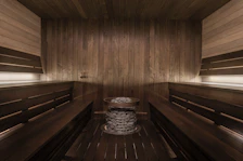 Relaxing sauna room with wooden benches and soft ambient lighting.