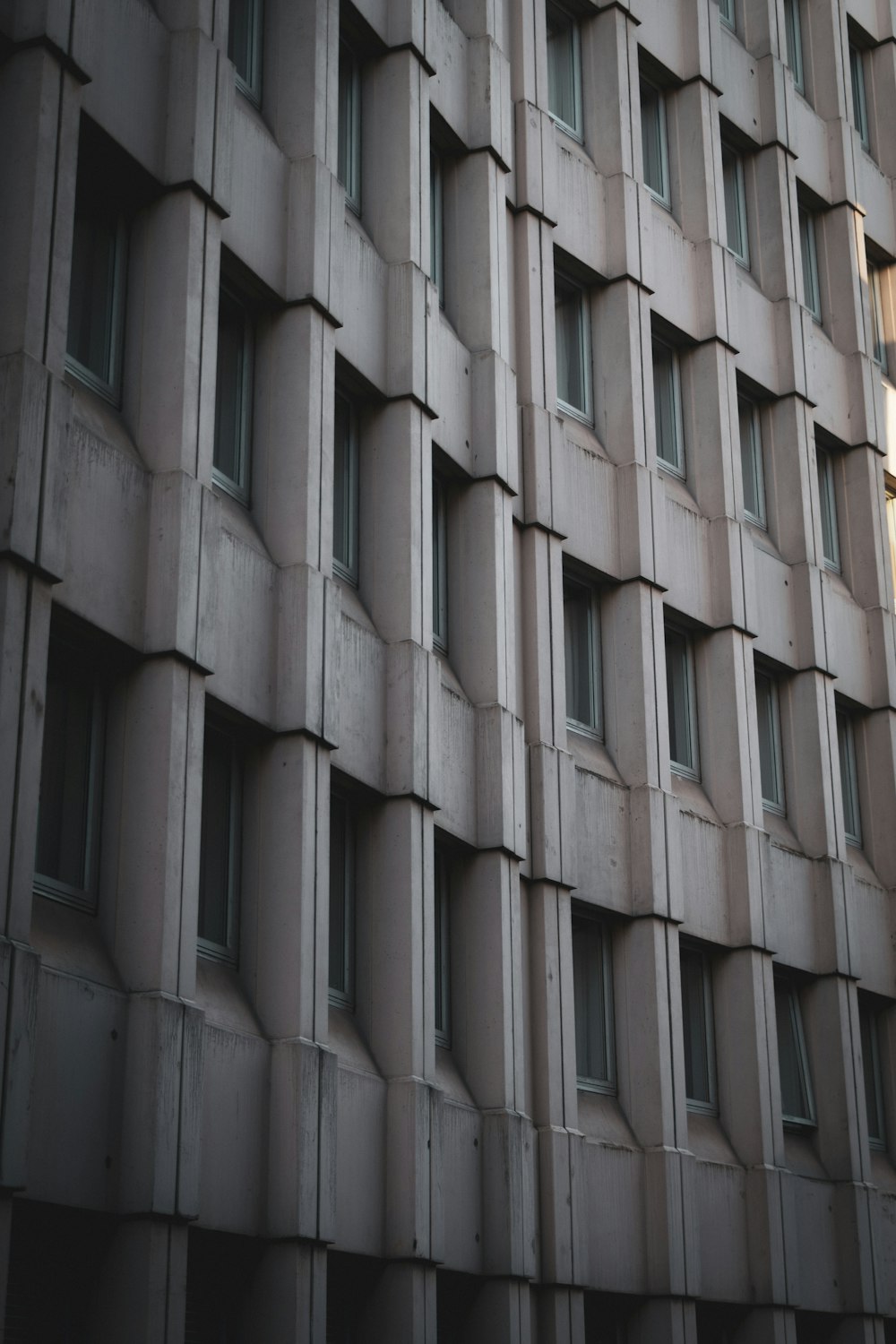 a tall building with lots of windows next to a street light