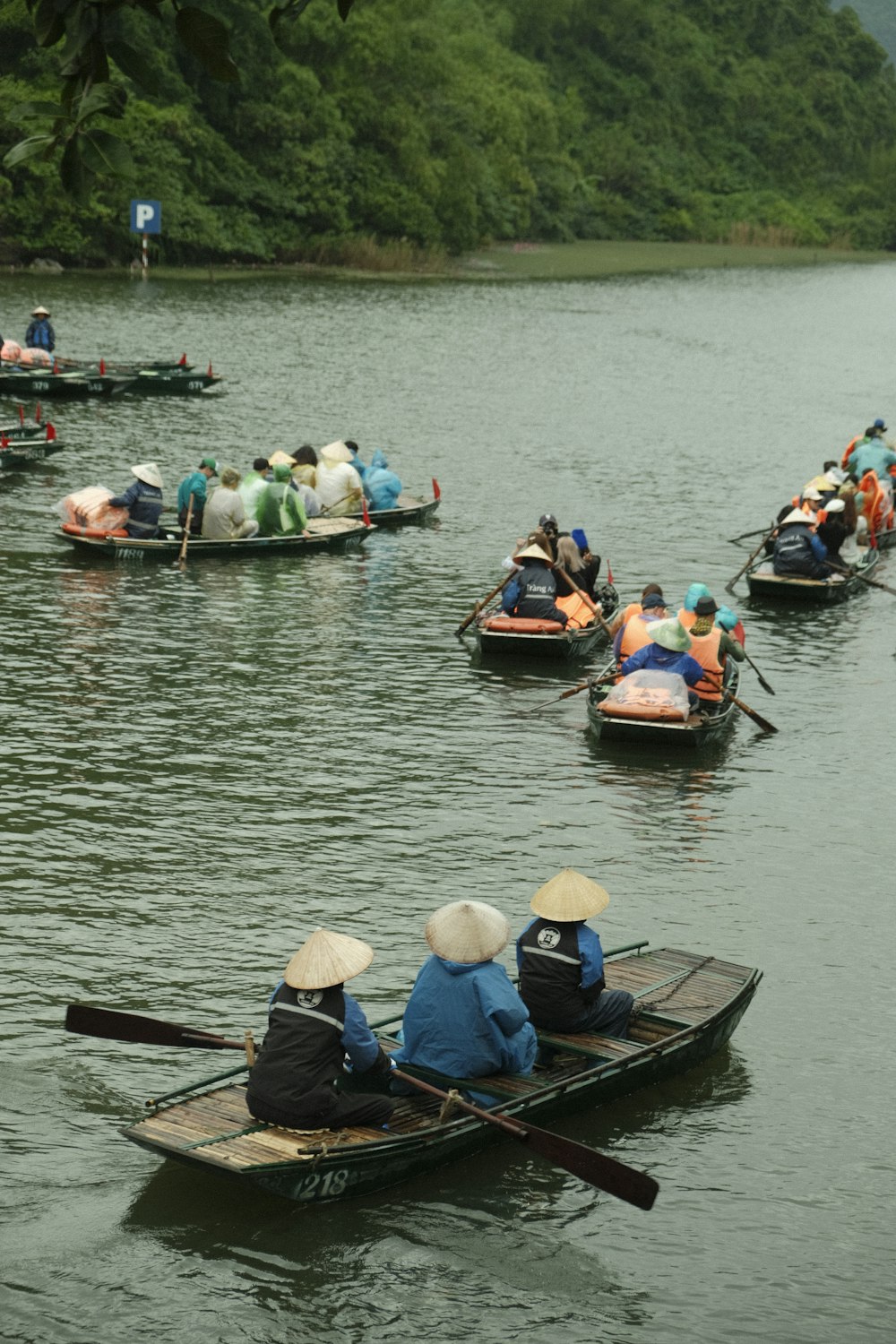 a group of people riding on top of small boats