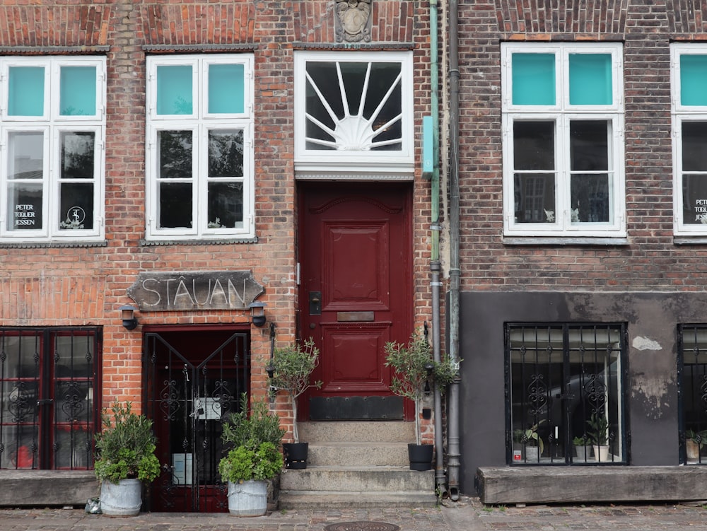 a brick building with a red door and windows