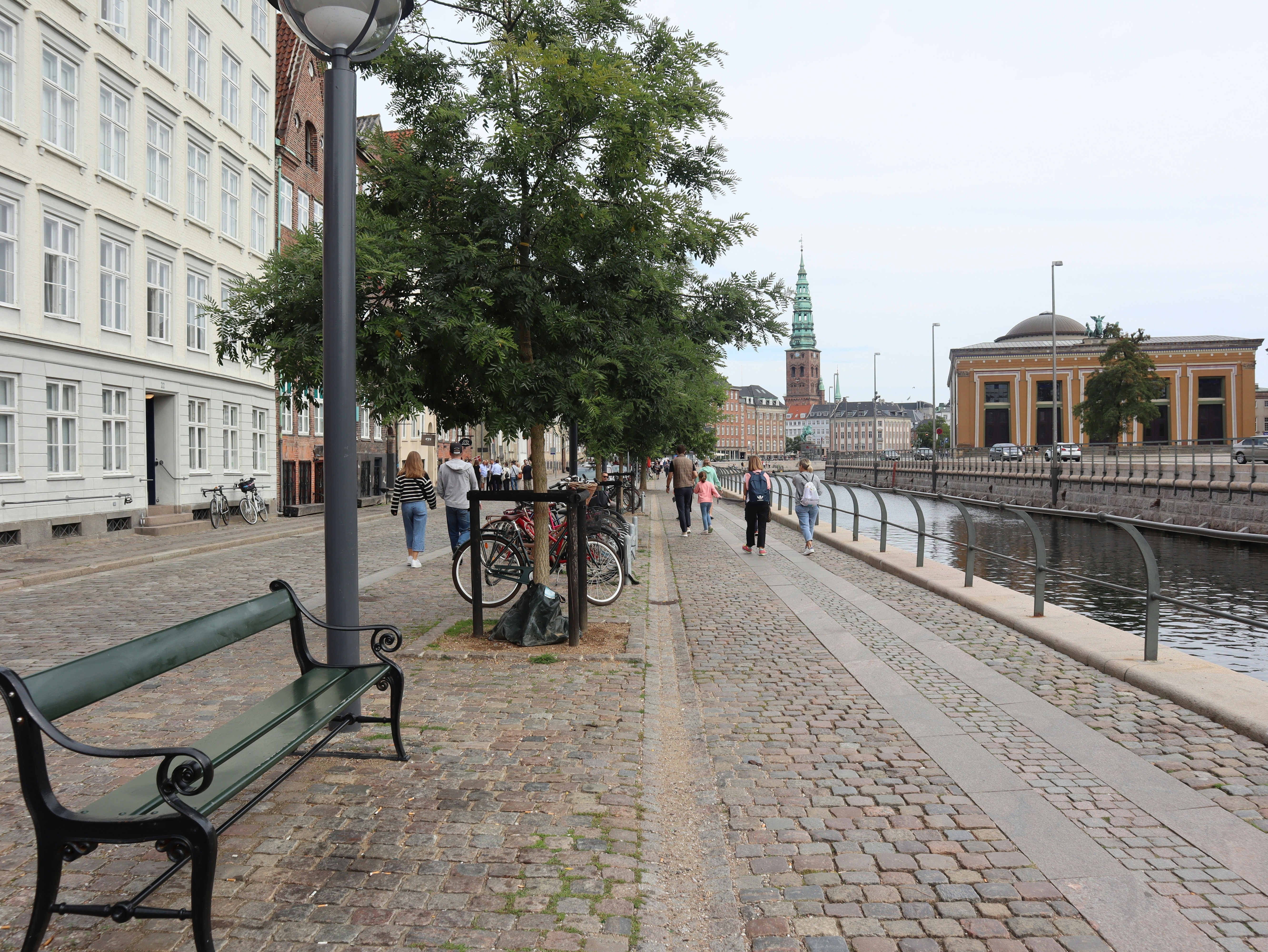 a bench sitting on the side of a road next to a river