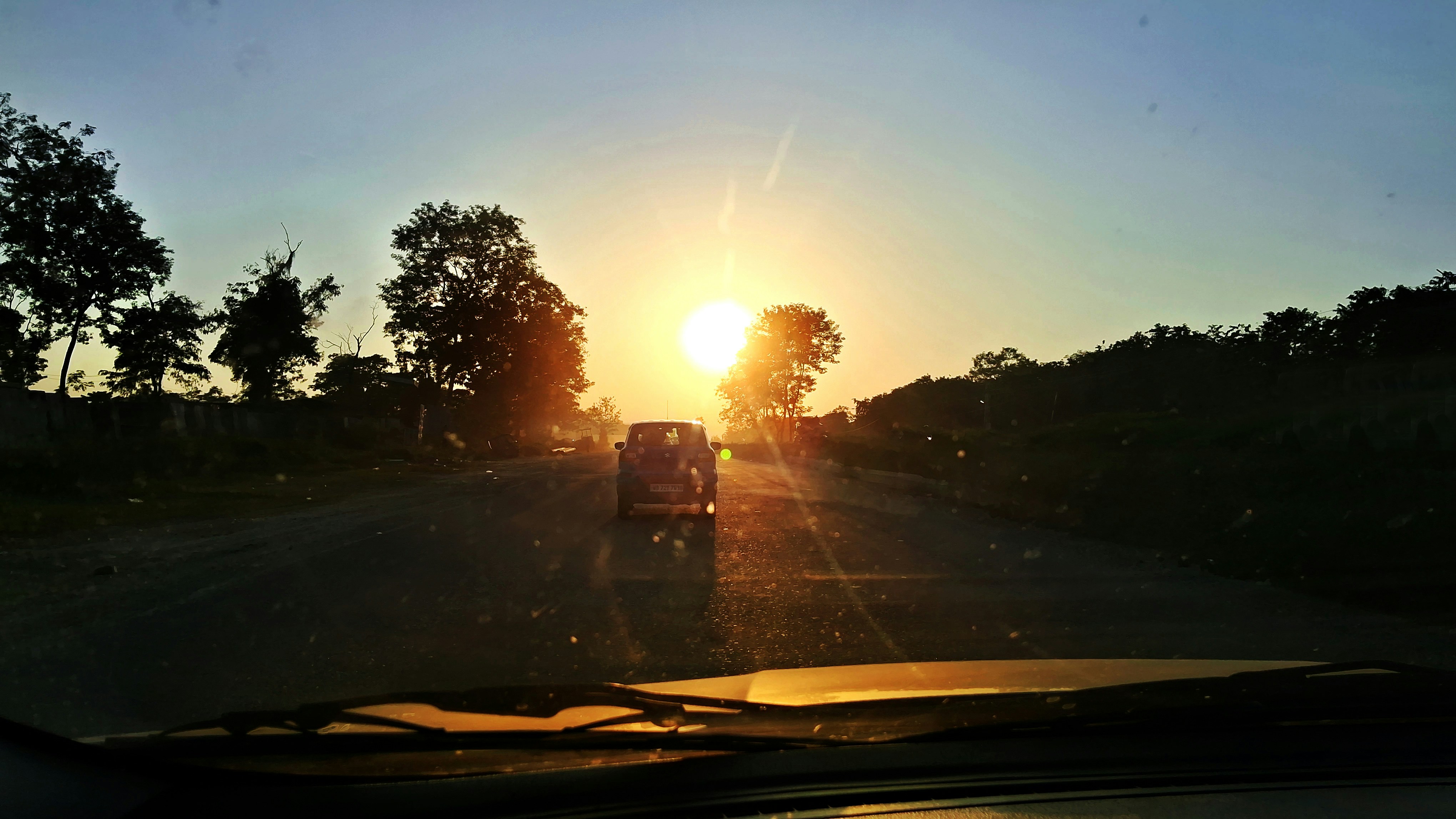 a car driving down a road at sunset
