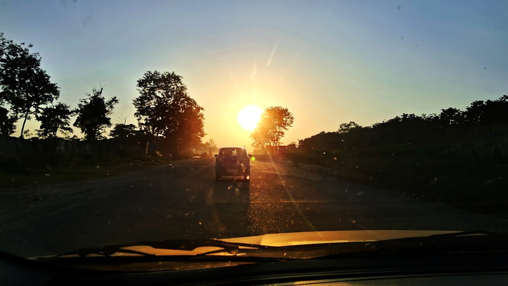 Un coche conduciendo por una carretera al atardecer