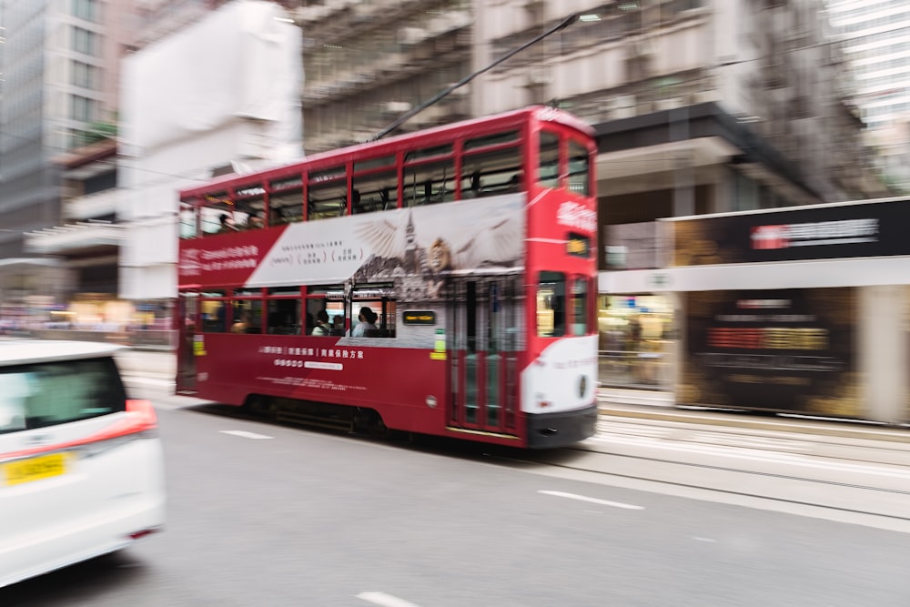 a red double decker bus driving down a street