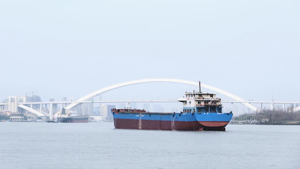 A detailed close-up of a cargo ship navigating the Paraná River under a clear blue sky.