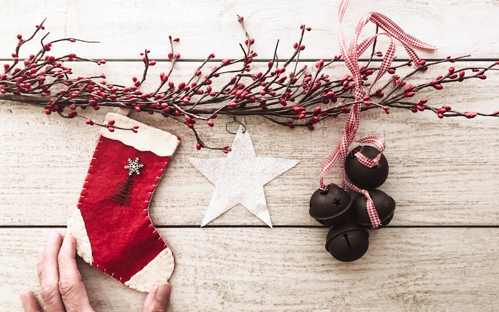 a person holding a christmas stocking next to a christmas tree