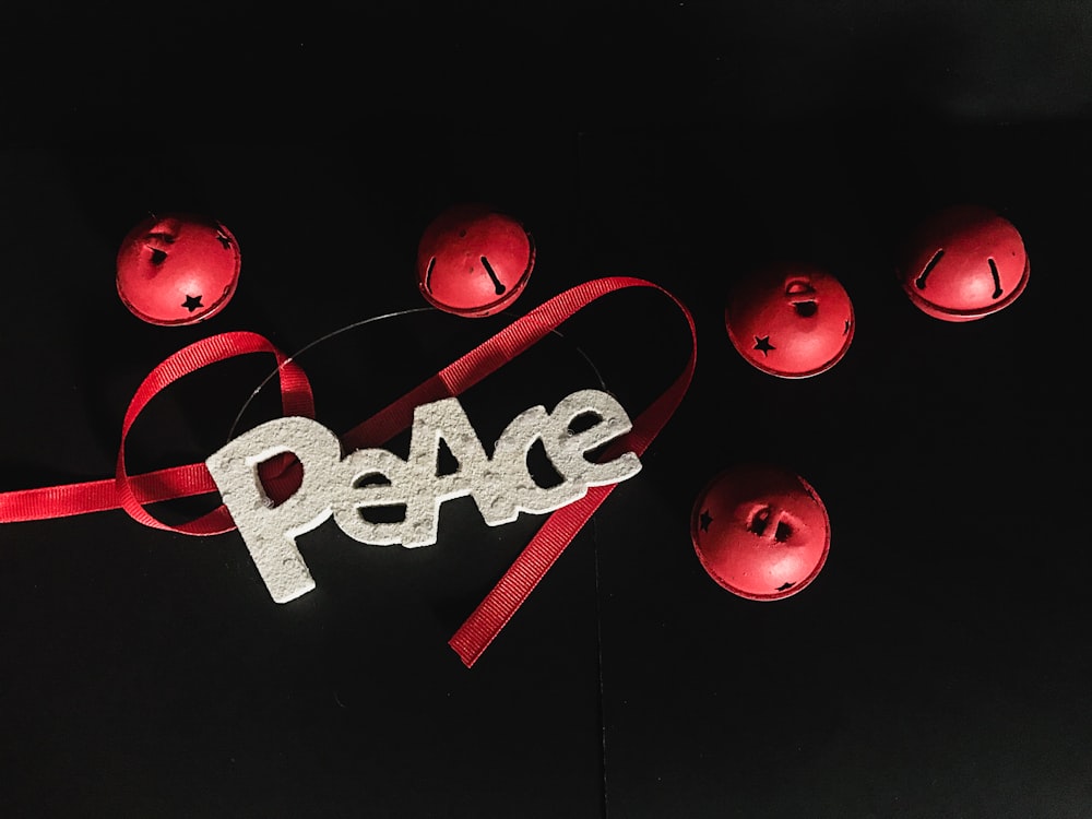 ein Peace-Zeichen mit einem roten Band drumherum