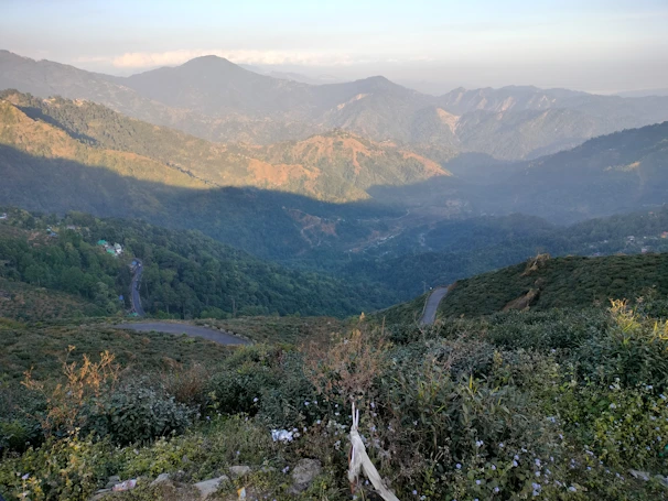 A panoramic view of the Atlas Mountains with winding roads and lush valleys.