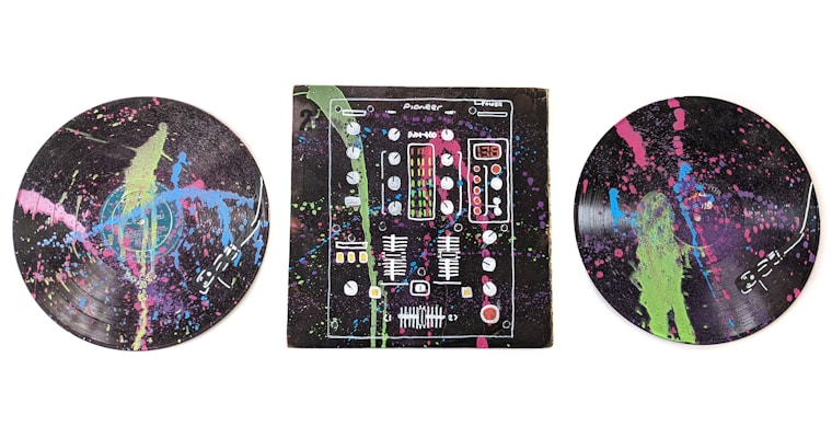 A colorful, abstract depiction of musical elements on vinyl records and a DJ mixer. The records and mixer are covered with splashes of bright neon colors including green, pink, and blue against a dark background.