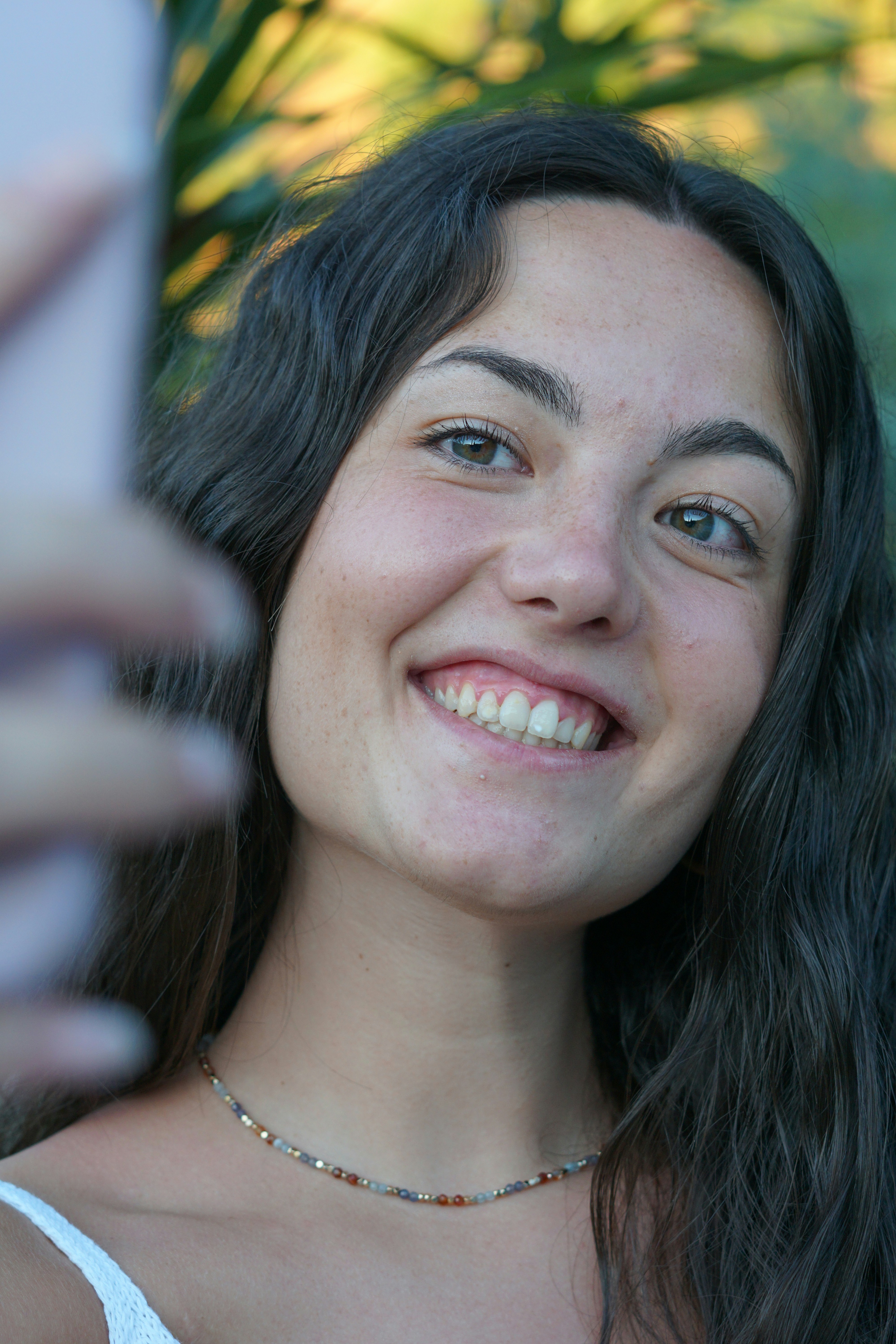 a woman is smiling and holding a cell phone