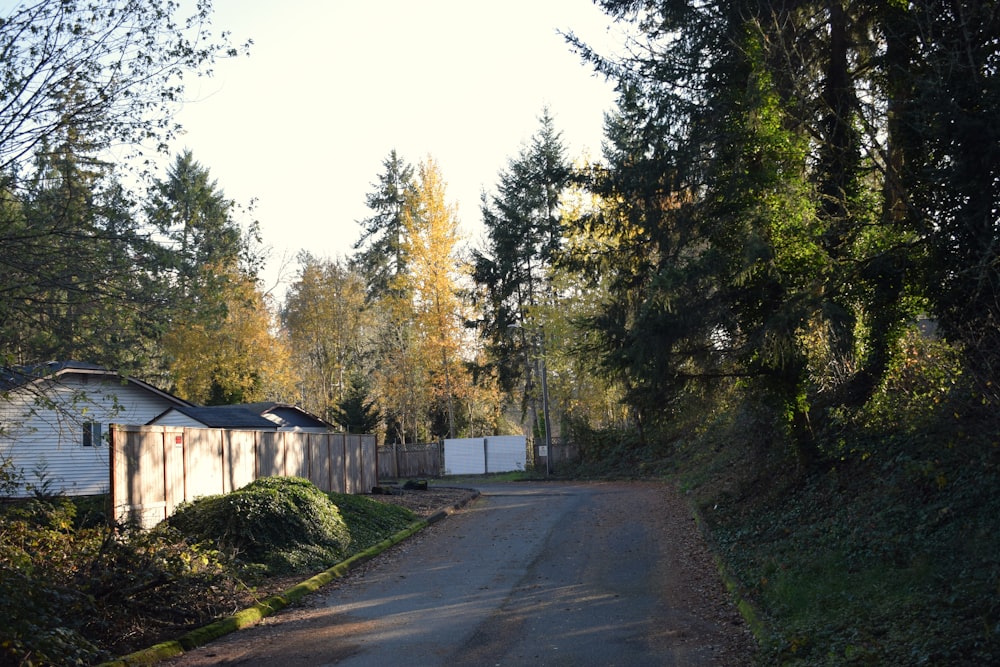 a street with a fence and a house in the background
