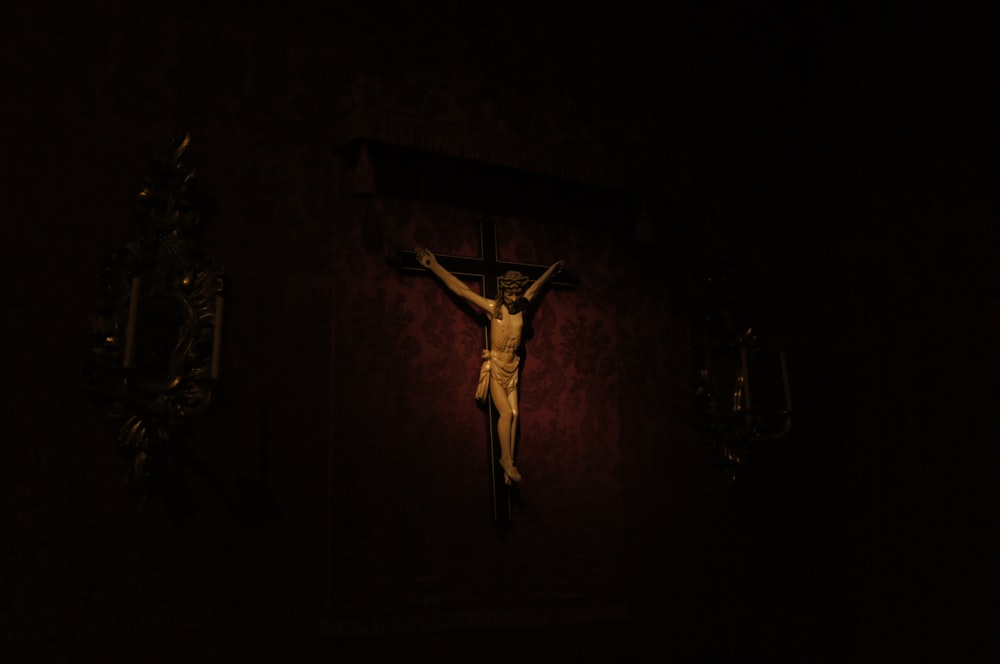 a crucifix in a dark room with a light shining on it