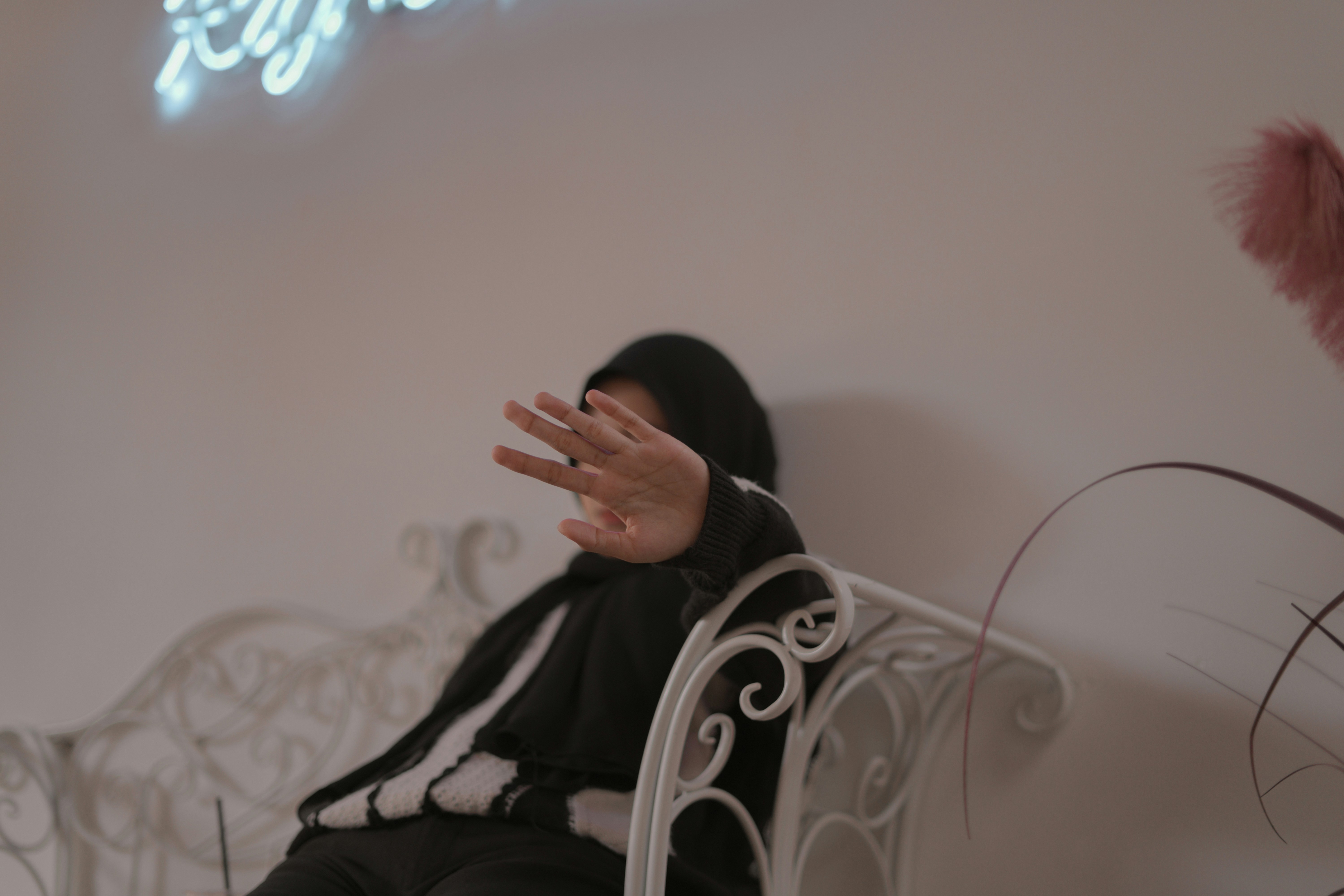 a woman sitting on a white bench with her hands in the air