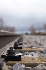 Close-up of a railway track measurement device in use on rails.
