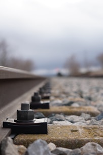 Close-up of a railway track measurement device in use on rails.