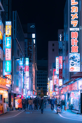 a busy city street at night with neon signs