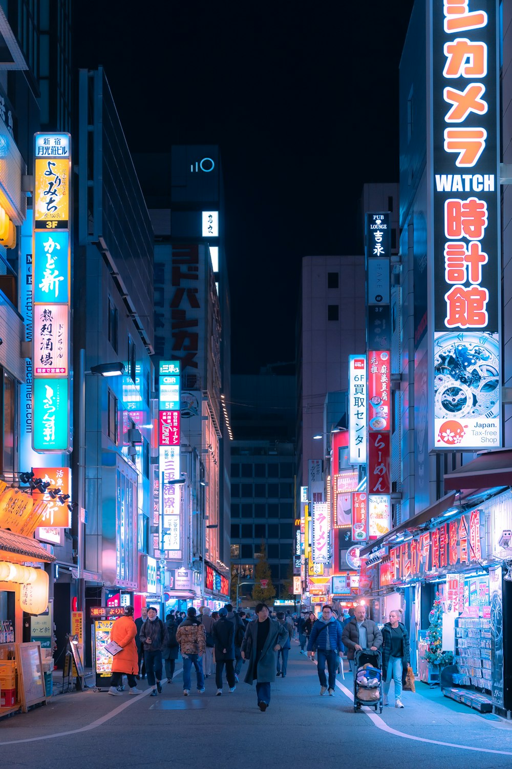 a busy city street at night with neon signs