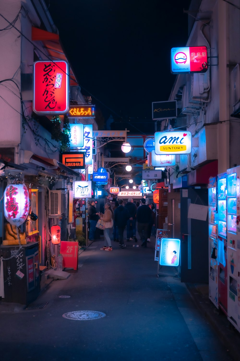 a city street at night filled with neon signs