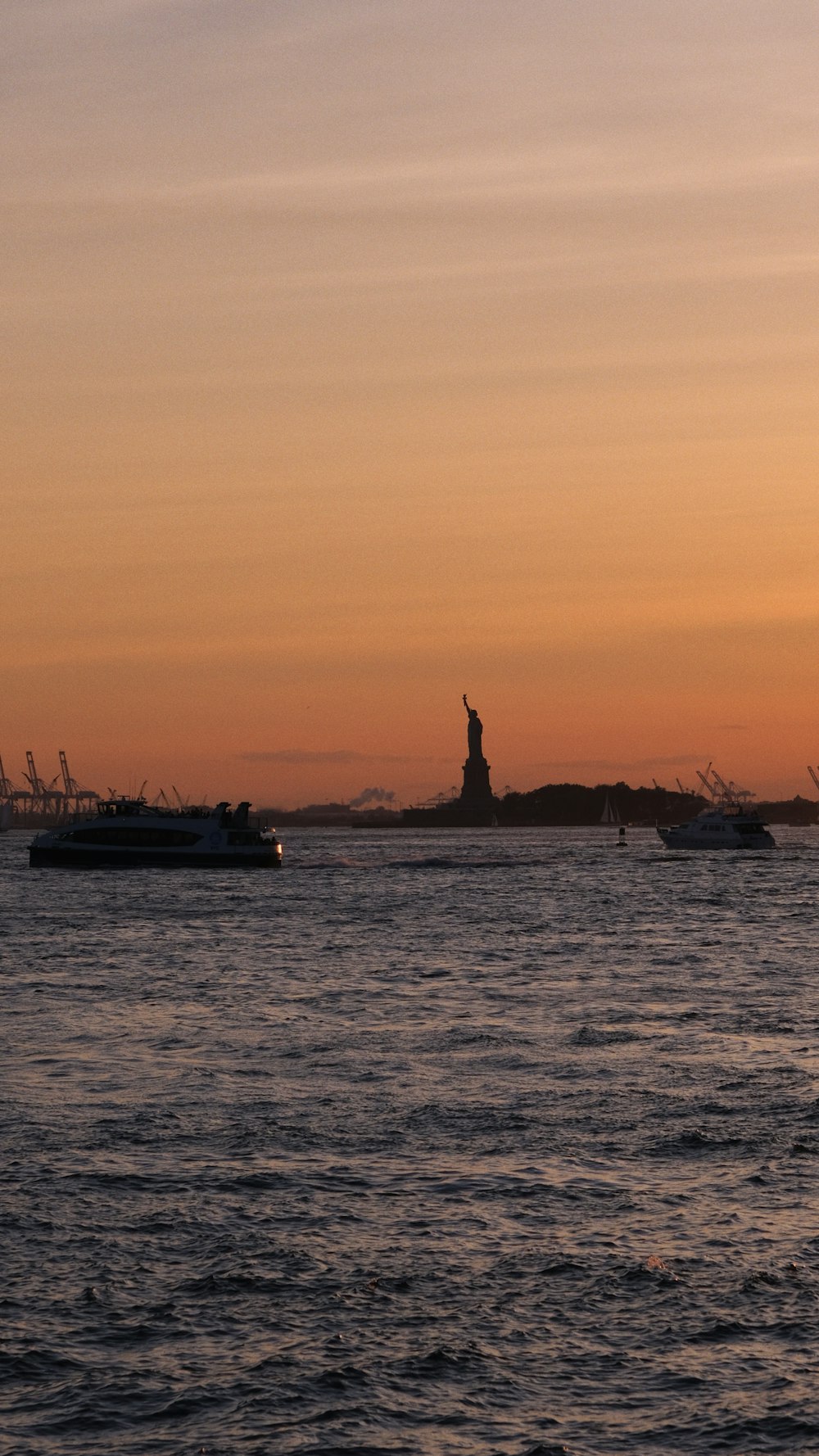 a large body of water with a statue of liberty in the distance