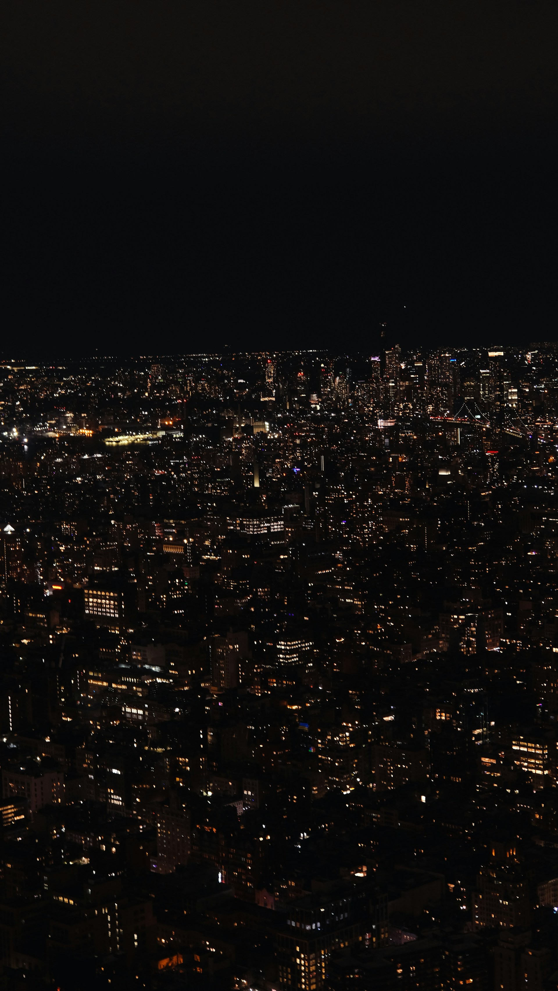 A bustling city skyline at night, illuminated by countless lights against a dark sky.