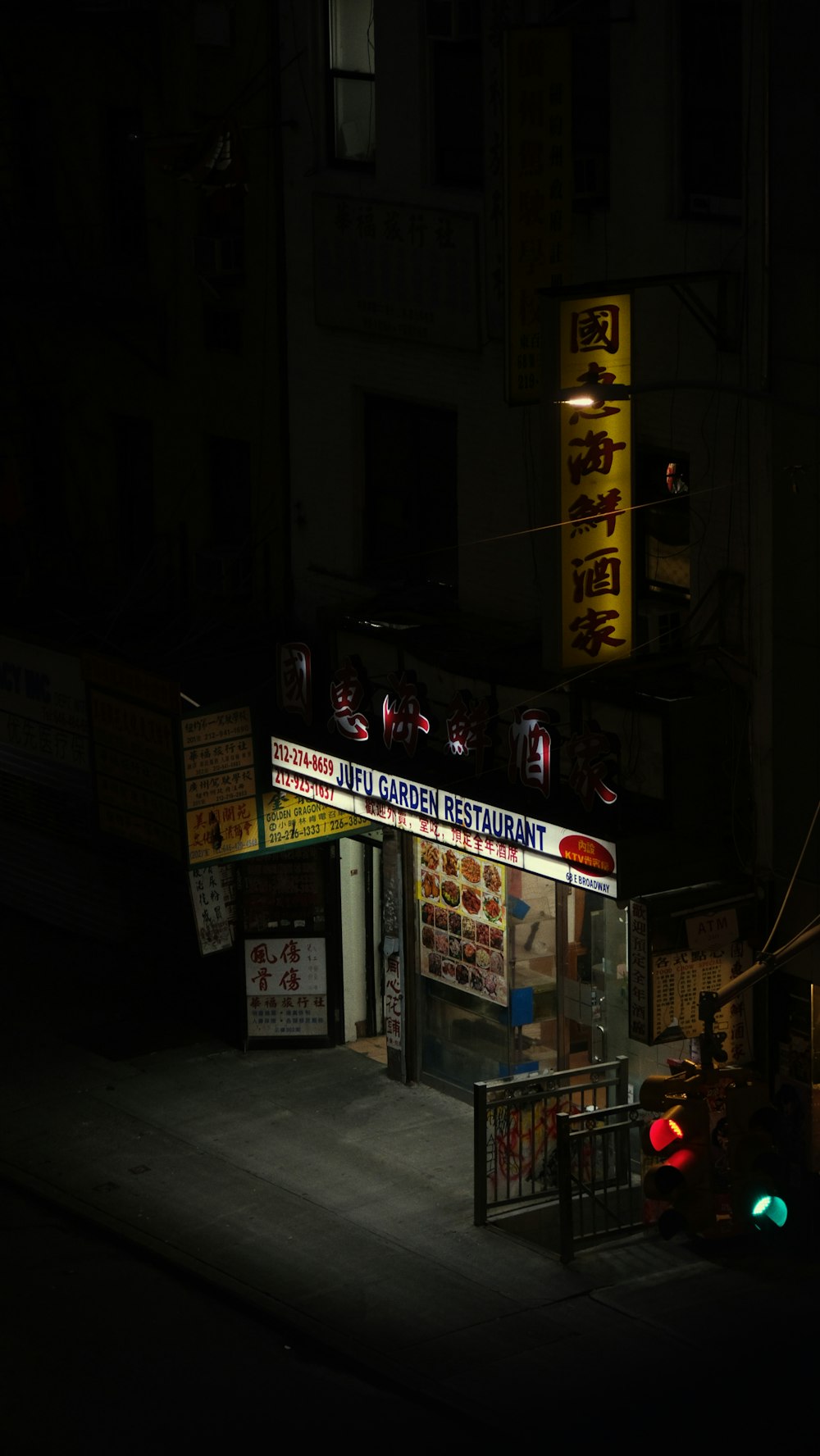 a dark street at night with a store front lit up