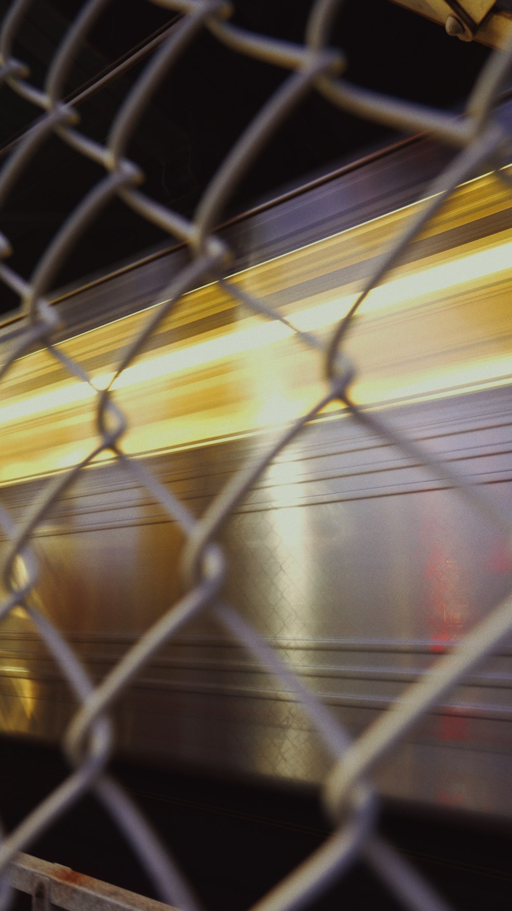 a blurry photo of a train passing by a fence