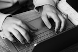 a person typing on a laptop on a desk
