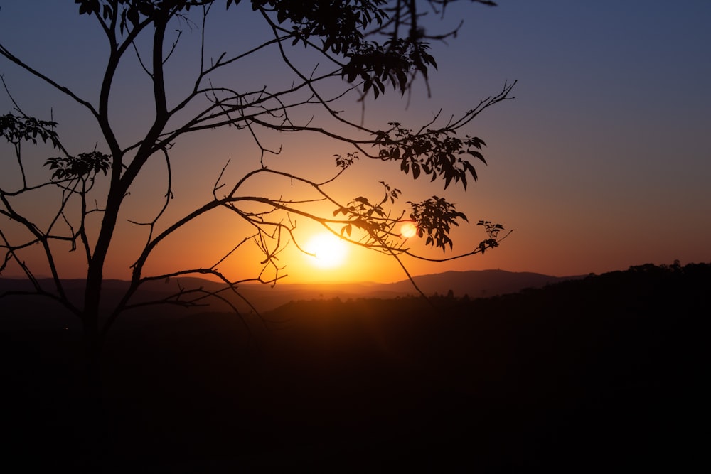 the sun is setting over a mountain range