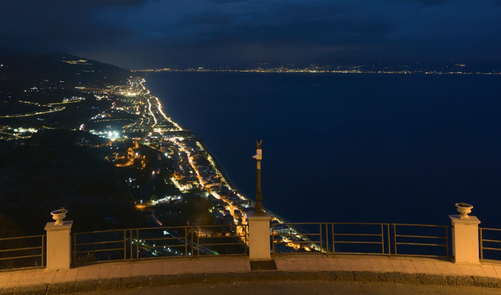 a night time view of a city and the ocean