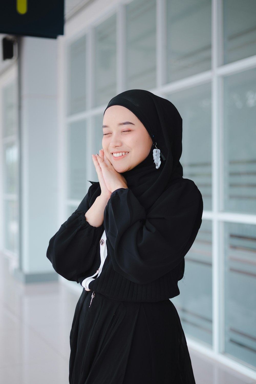 a woman in a hijab standing in front of a building