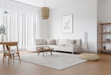 Minimalist living room with natural wood furniture and soft textiles.