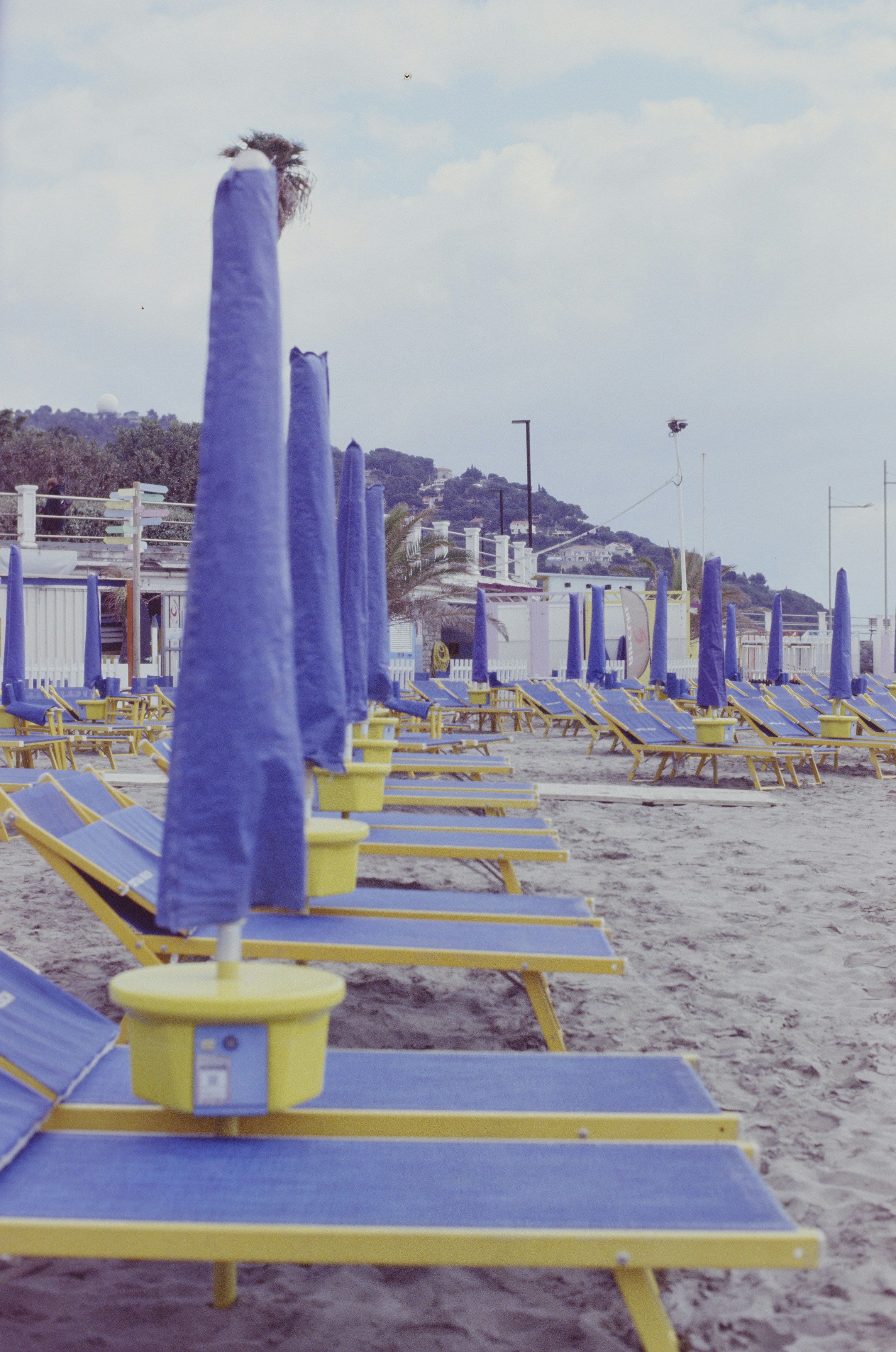a row of blue and yellow beach chairs and umbrellas