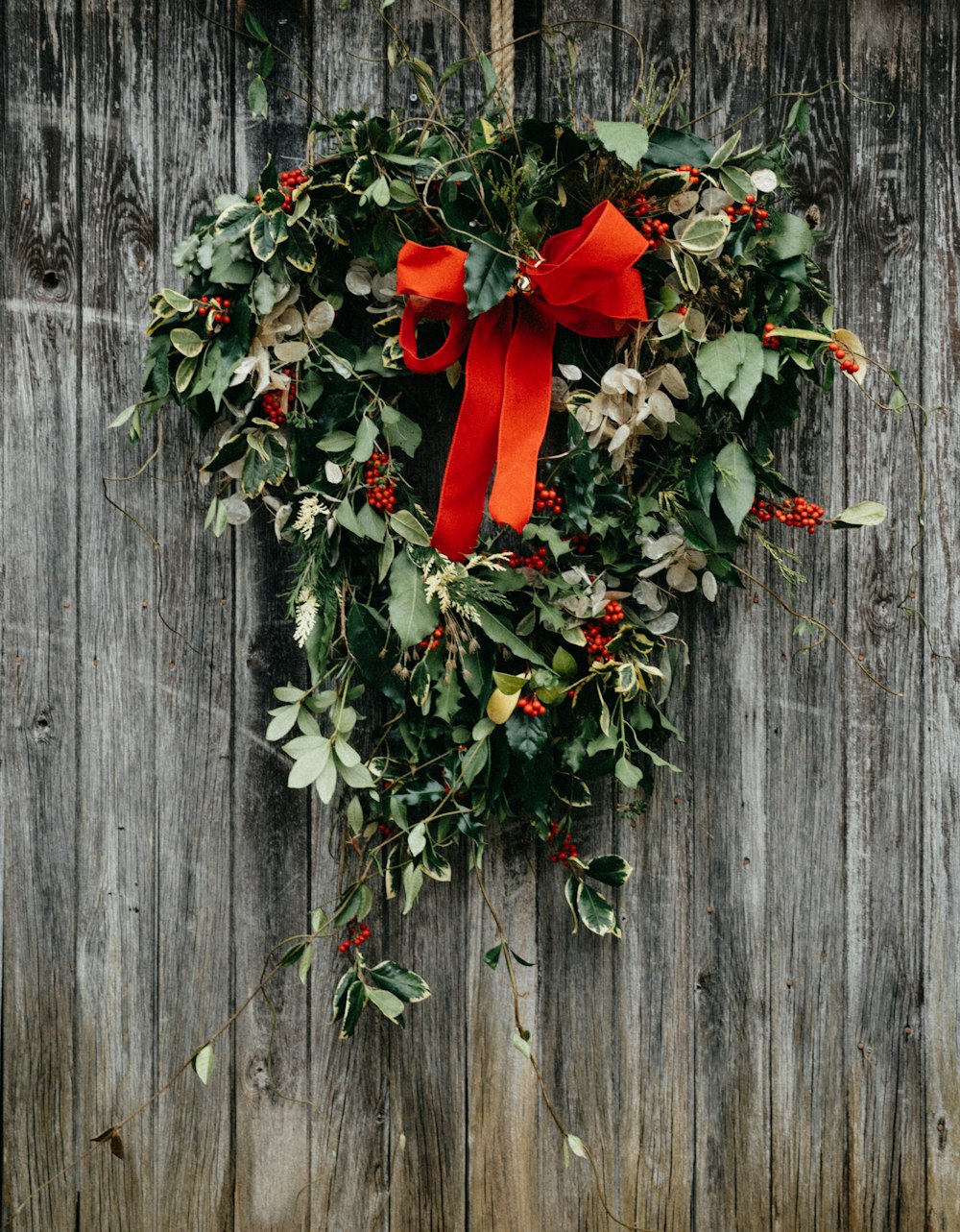 a wreath hanging on the side of a wooden fence