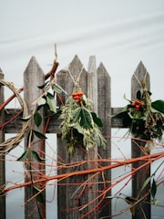 A festive Christmas cedar garland draped along a rustic wooden fence